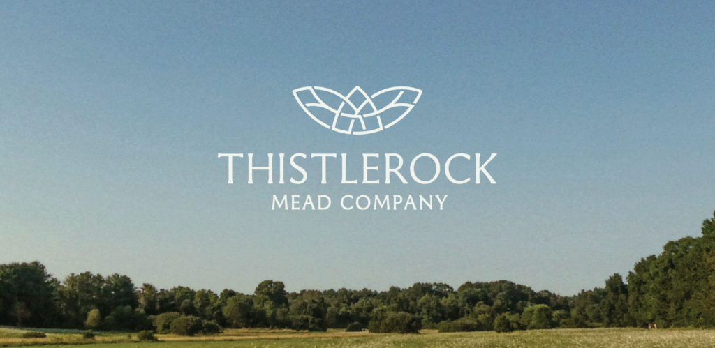 Thistlerock logo deisgn overlaid on image of open meadow